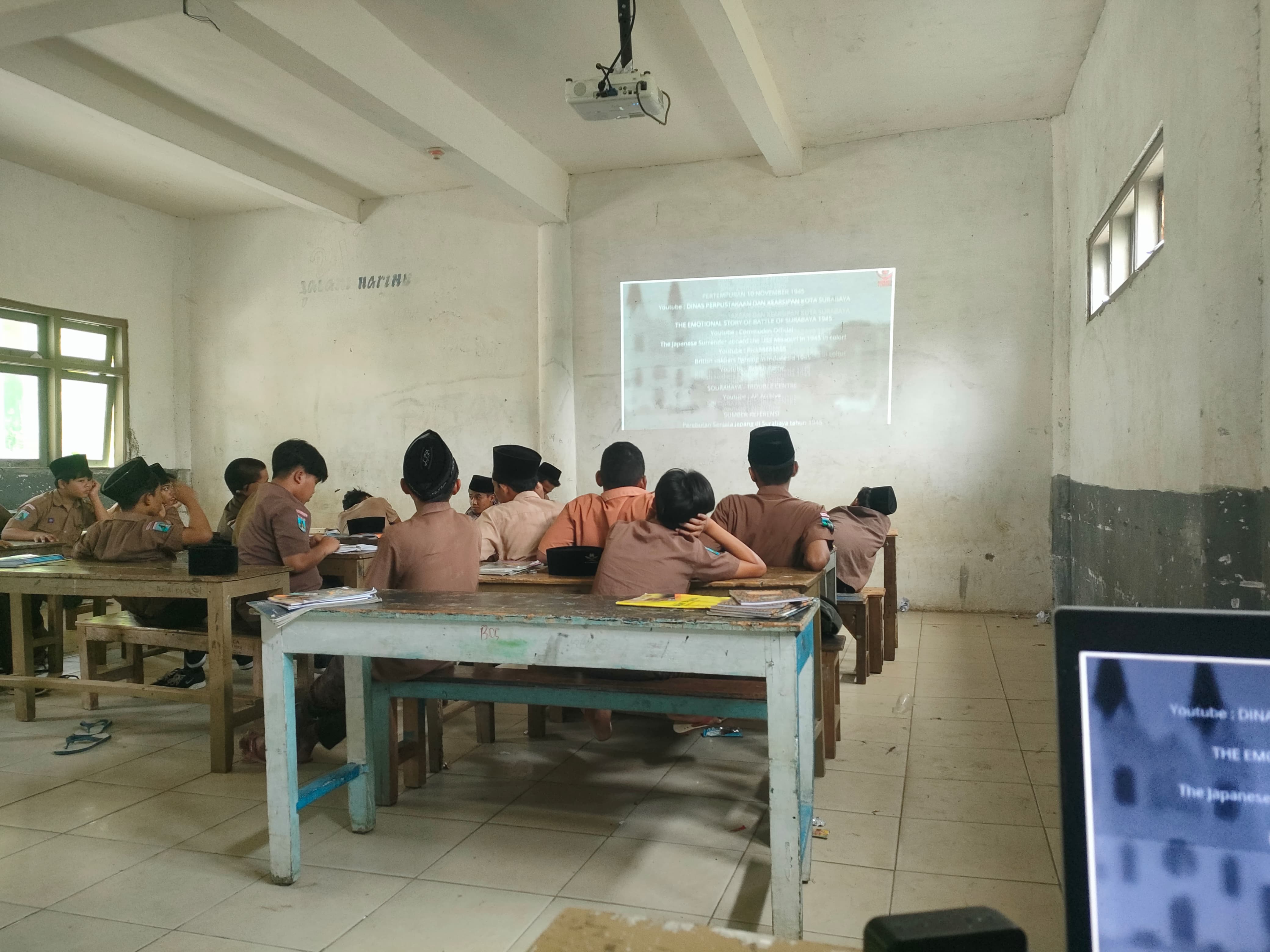 salah satu guru sedang menayangkan video awal mula perjuangan rakyat Surabaya 10 Novmber 2024